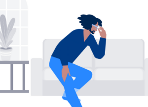 Man sitting on couch stressed with hand on forehead