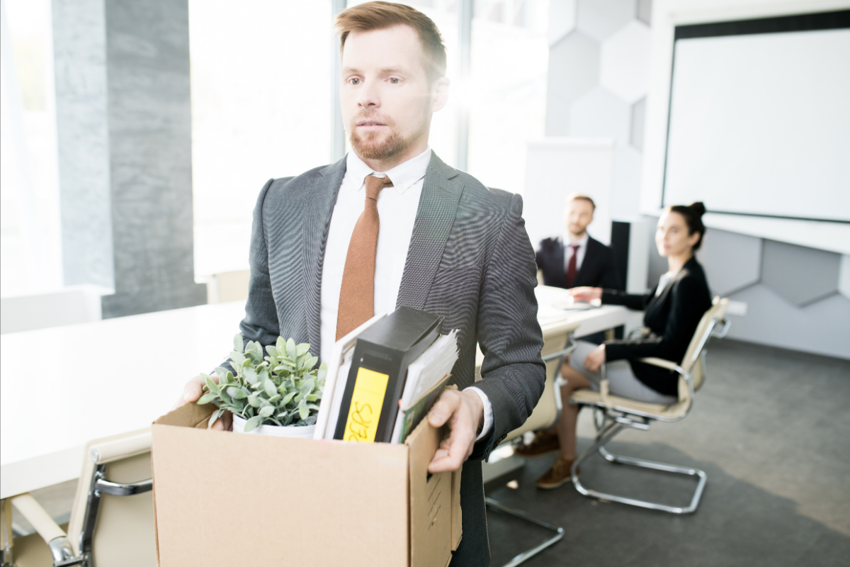 Man walking out of office with things in a box